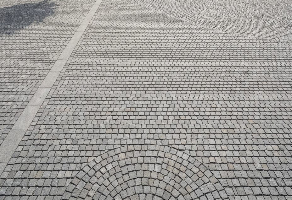 Close view of basalt sett paving in fan bond with a granite kerb