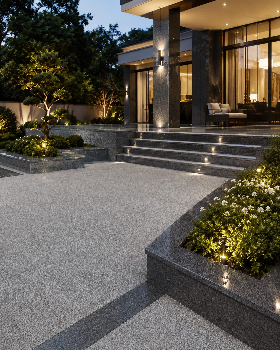 Polished and worked Georgian granite paving and steps at a contemporary villa, lit at dusk